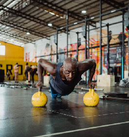 Personal Training Client man doing push ups on dumbells